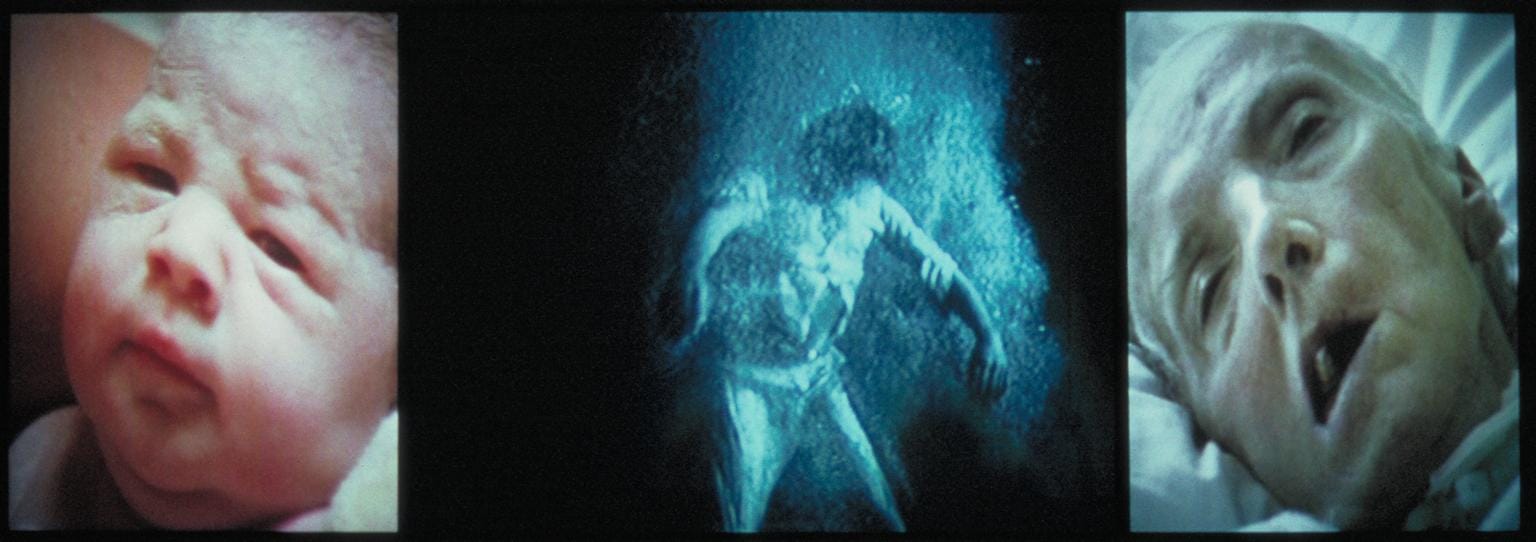 A triptych of video images, with a baby on the left, a figure submerged in water in the center, and an old man on the right.