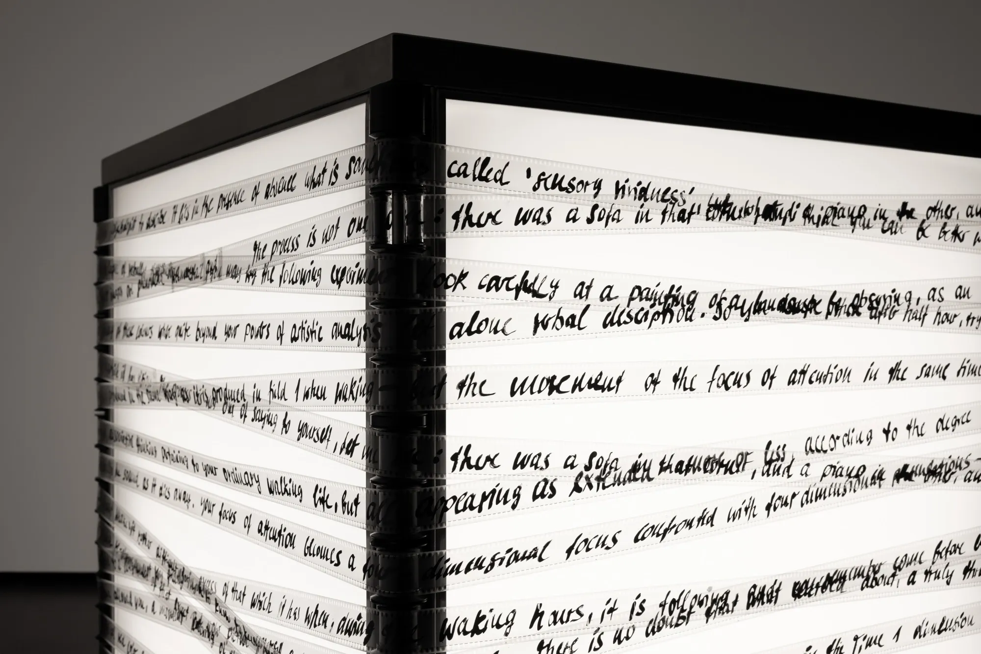 A lightbox with film strips spread across it featuring handwritten messages on it.