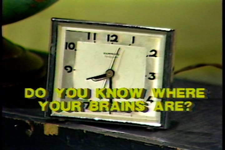A clock with hands positioned at 8:30, with words in yellow printed over it in the style of an old video effect generator that read Do You Know Where Your Brains Are?